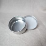 small round soap tin with lid off by its side